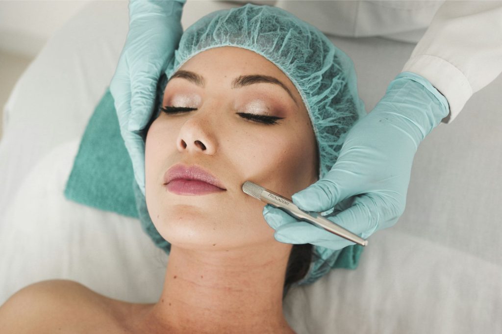 Cosmetic procedure, skincare professional, close-up treatment.